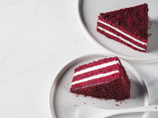 Piece of red velvet cake with perfect texture in matte plate on white marble tabletop. Slice of delicious homemade red velvet cake with raspberry and chocolate.Copy space for text.Top view or flat lay