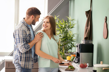 Happy young couple cooking together in kitchen