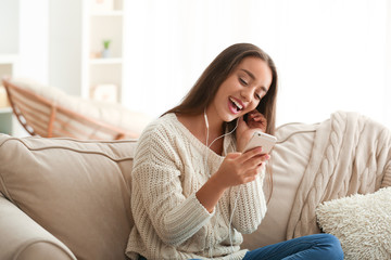 Canvas Print - Beautiful young woman listening to music at home