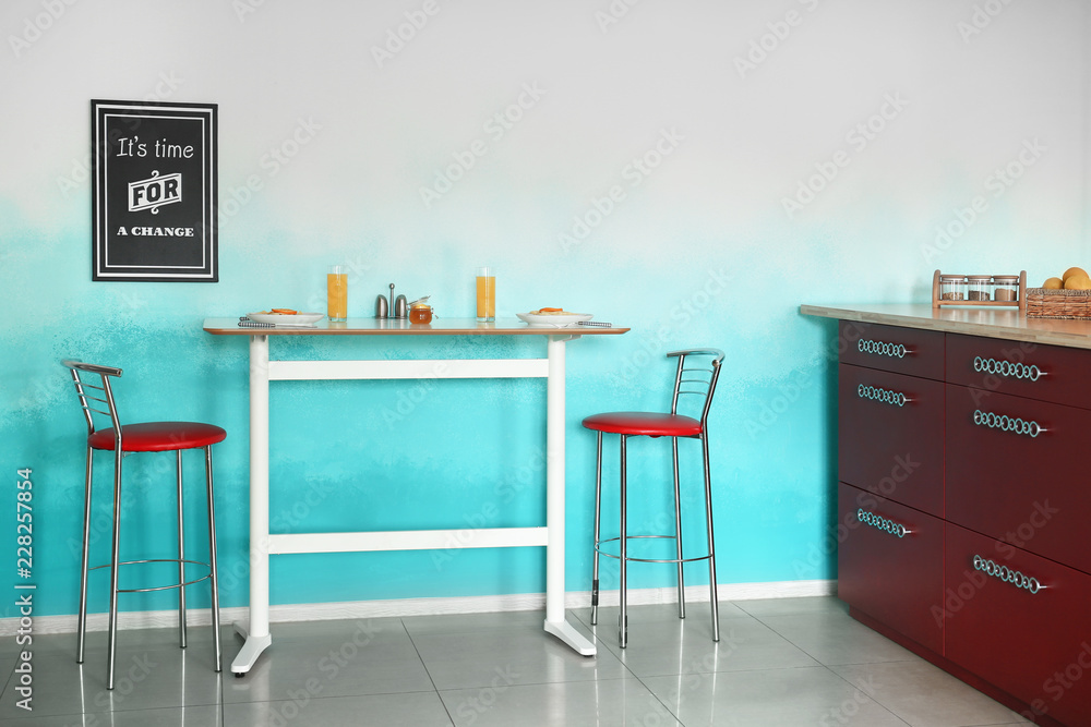 Modern light table with chairs in stylish kitchen