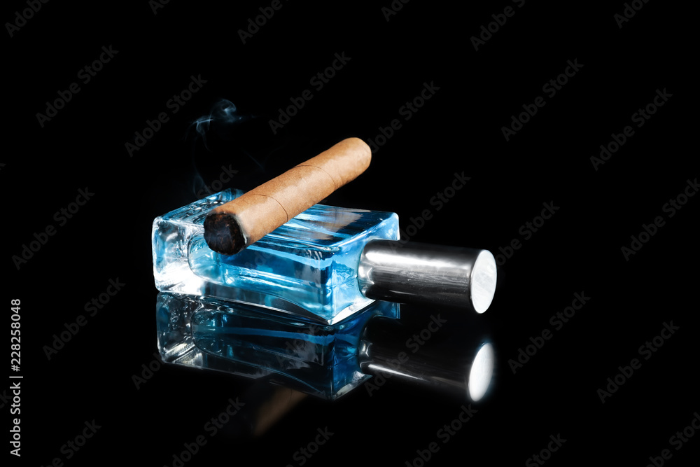 Bottle of perfume with cigar on dark background