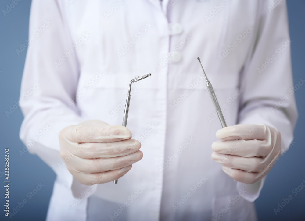 Dentist holding stainless instruments, closeup