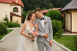 © Wedding photography - Wedding couple. Happy bride with wedding bouquet holds the groom's arm. Stylish newlywed couple. Marriage concept. Rustic wedding