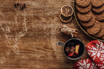 Wall Mural - top view of mulled wine in cup, mittens and cookies on wooden tabletop, christmas concept