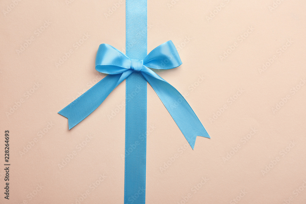 Blue ribbon with bow on color background