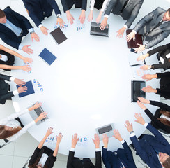 Canvas Print - group of business people sitting at the round table, and putting his palms on the table