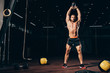 © LIGHTFIELD STUDIOS - handsome athletic man holding kettlebell overhead while working out  in dark gym