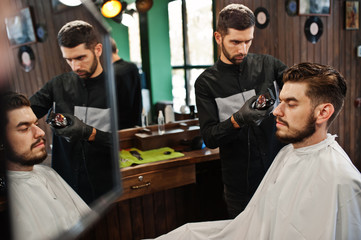 Wall Mural - Handsome bearded man at the barbershop, barber at work.