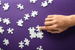 © Pixel-Shot - Hand of woman doing puzzle on color background