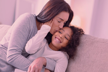 Wall Mural - Mothers love. Delighted nice woman hugging her daughter while giving her a kiss