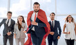 © ASDF - businessman superhero and his business team are stepping togethe