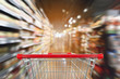 © Kwangmoozaa - supermarket aisle blur abstract background with empty red shopping cart