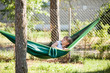 © Cimermane - Little child girl lying in the green hammock smiling at sunny summer day on holidays outdoor in garden