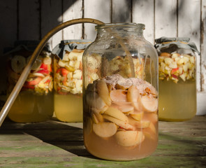 Wall Mural - Making of apple vinegar - apple pieces floating on water in a glass