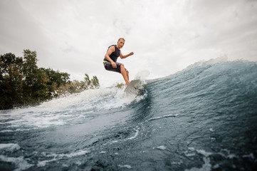 Wall Mural - Side view active boy riding on the white wakeboard