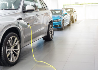 Close up of the Hybrid car electric charger station with power supply plugged into an electric car being charged.	