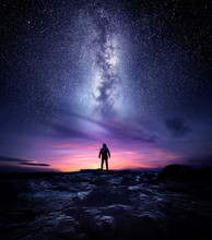 Night Time Long Exposure Landscape Photography. A Man Standing In A High Place Looking Up In Wonder To The Milky Way Galaxy, Photo Composite.