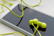 © marketlan - Modern smartphone with lime headphones on light background. Closeup, selective focus