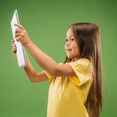 Teen girl with laptop. Love to computer concept. Attractive female half-length portrait, trendy green studio backgroud. Human emotions, facial expression concept.