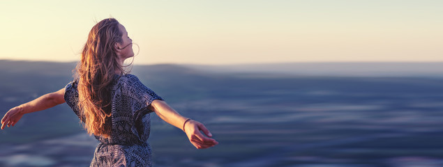 christian worship and praise. a young woman with her hands raised in worship and praise to god.