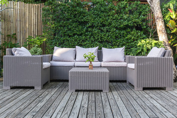 Large terrace patio with rattan garden furniture in the garden on wooden floor.