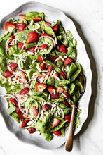 Overhead View Of Strawberry Spinach Salad Served On Plate On Table
