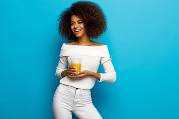 Wall Mural - Beautiful smiling african american girl with a glass of orange juice