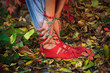 closeup of woman legs and hands in yoga stretch pose in colorful autumn leaves outdoor