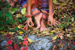 barefoot  woman legs and hands in yoga and mudra gesture in colorful autumn leaves outdoor