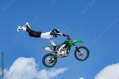 Dekoracja na wymiar  zawodnik-na-motocyklu-w-locie-skacze-i-startuje-na-trampolinie-na-tle-blekitnego-nieba
