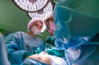 © Georgii - Surgeon and his assistant performing cosmetic surgery on nose in hospital operating room. Nose reshaping, augmentation. Rhinoplasty.