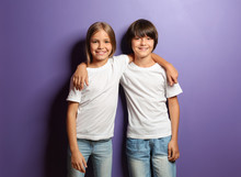 Boy And Girl In T-shirts Hugging Each Other On Color Background