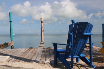 Poster - tropical colored chairs by the ocean