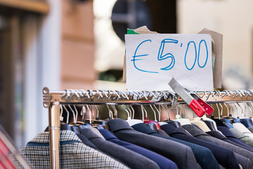 Men suits second hand on a rack for sell at cheap price at a street market in Ancona Italy.