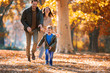 © Mediteraneo - Young family having fun in the autumn park with his son.