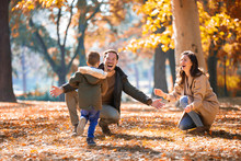Young Family Having Fun In The Autumn Park With His Son.