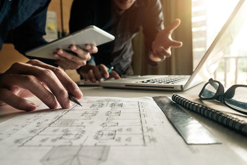 Wall Mural - two colleagues discussing data working and tablet, laptop with on on architectural project at constr