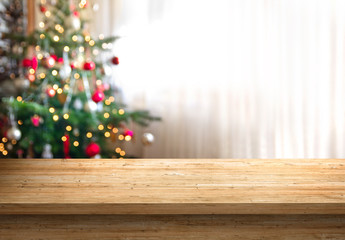 empty wood table top and blur of room with a christmas tree background, suitable for montage product display