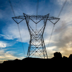 Silhouetted power line against a vast cloudy sky