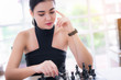 © totojang1977 - Beautiful attractive businesswoman playing chess at office. thinking about strategy, management or leadership concept.