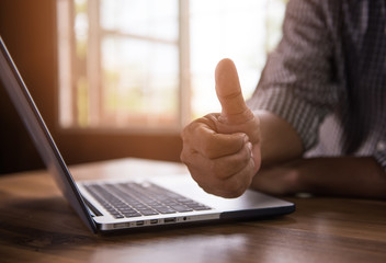 Businessman with the notebook showing thumbs up in office 