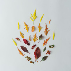 Minimal autumn nature composition. Camp fire made of autumn leaves and branches on white table background. Flat lay top view.