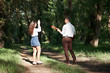 © soleg - young couple walking in the forest, playing guitar and dancing, summer nature, bright sunlight, shadows and green leaves, romantic feelings