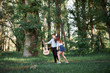 © soleg - young couple walking in the forest and playing guitar, summer nature, bright sunlight, shadows and green leaves, romantic feelings