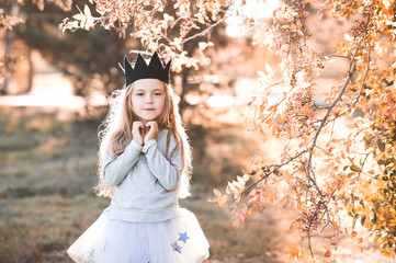 cute bby girl 4-5 year old wearing handmade crown and trendy clothes outdoors. autumn season. childh