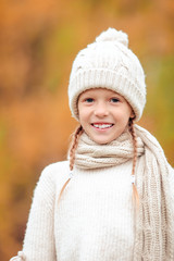 Wall Mural - Portrait of adorable little kid with yellow leaves in fall. Autumn time