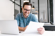 © bnenin - Handsome young smiling businessman working with documents.