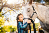 in a beautiful Autumn season of a young girl and horse