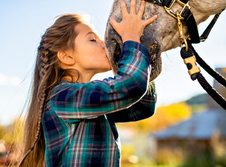 in a beautiful Autumn season of a young girl and horse