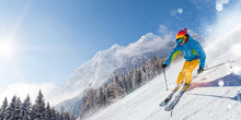 Skier Skiing Downhill In High Mountains